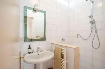 a white bathroom with a sink and a mirror at Urban Terrace Merulana - by OpenRoma in Rome