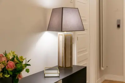 a lamp on a table next to a vase of flowers at Decòncept House in Rome