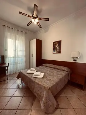 a bedroom with a bed and a ceiling fan at Karina Suite in Rome