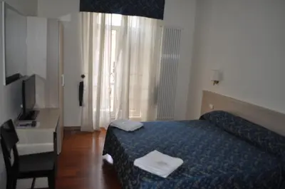 a bedroom with a bed and a desk and a television at Karina Suite in Rome