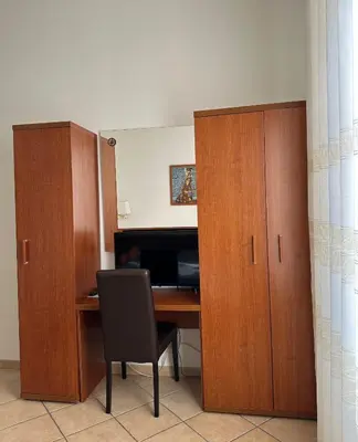 an office with a desk with a chair and wooden cabinets at Karina Suite in Rome