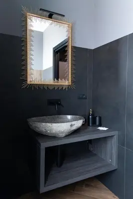 a bathroom with a stone sink and a mirror at One of one Experiences - LOVE SPA SUITE in Rome