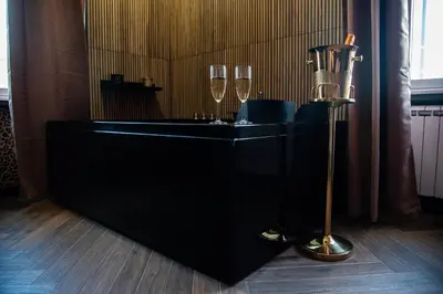 a black counter with two wine glasses and a lamp at One of one Experiences - LOVE SPA SUITE in Rome