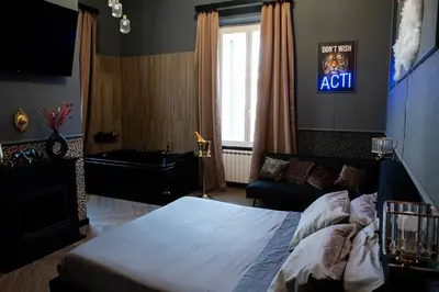 a bedroom with a bed and a tv and a couch at One of one Experiences - LOVE SPA SUITE in Rome