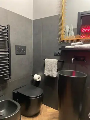 a bathroom with a black toilet and a sink at One of one experiences - LOVE ROOM in Rome