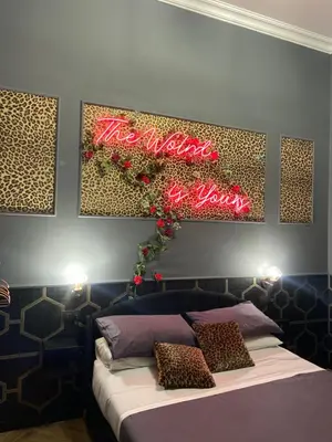 a bed with a sign that says the world is yours at One of one experiences - LOVE ROOM in Rome
