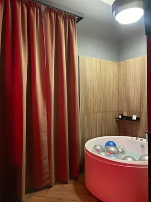 a bath tub in a bathroom with a red curtain at One of one experiences - LOVE ROOM in Rome