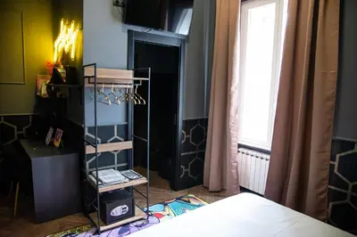 a room with a bed and a window and a shelf at One of one experiences - ART ROOM in Rome