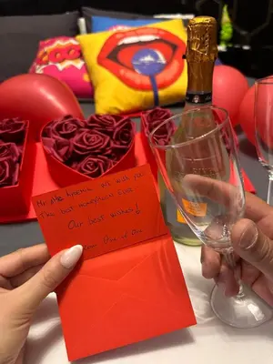 a person holding a red envelope and a bottle of wine at One of one experiences - ART ROOM in Rome