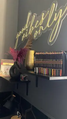 a neon sign on a wall with books on a shelf at One of one experiences - ART ROOM in Rome