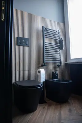 a bathroom with a black toilet and a tub at One of one experiences - ART ROOM in Rome