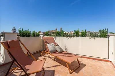 a couple of chairs sitting on a balcony at iFlat Spanish Steps Unique Panoramic Penthouse in Rome