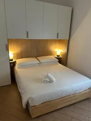 a bedroom with a large bed with white sheets and cabinets at Casa Garbata in Rome