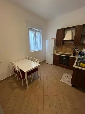 a kitchen with a table and a white refrigerator at Casa Garbata in Rome