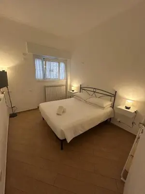 a bedroom with a bed with white sheets and a window at Casa Garbata in Rome