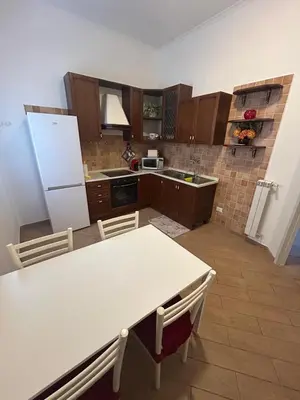 a kitchen with a table and a white refrigerator at Casa Garbata in Rome