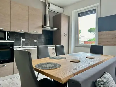 a kitchen with a wooden table with chairs around it at Aurum Homes - Vaticano Lux Appartament in Rome