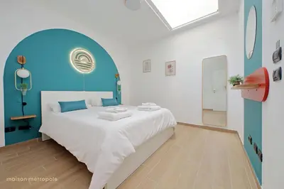 a bedroom with a large bed with a blue headboard at Color House, roof garden & parking in Rome