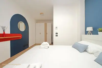 a bedroom with a large white bed and a blue wall at Color House, roof garden & parking in Rome