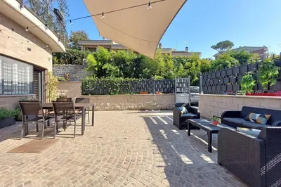 a patio with chairs and tables and an umbrella at Color House, roof garden & parking in Rome