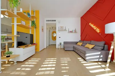a living room with a couch and a red wall at Color House, roof garden & parking in Rome