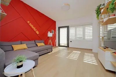 a living room with a couch and a red wall at Color House, roof garden & parking in Rome