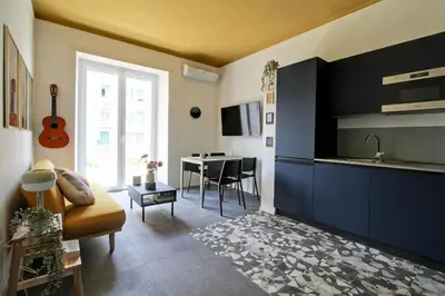a living room with a couch and a kitchen with a table at Roma Academia Style by the Halls of Knowledge in Rome