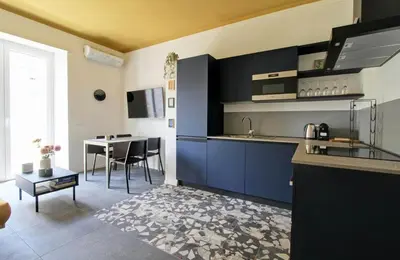 a kitchen with blue cabinets and a table in a room at Roma Academia Style by the Halls of Knowledge in Rome