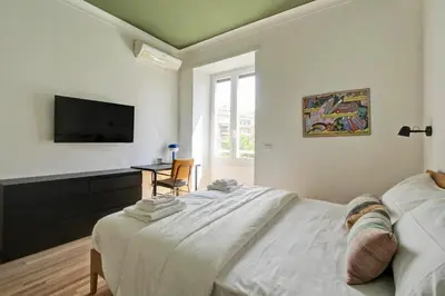 a bedroom with a large bed and a television at Roma Academia Style by the Halls of Knowledge in Rome