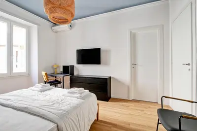 a bedroom with a bed and a desk and a television at Roma Academia Style by the Halls of Knowledge in Rome