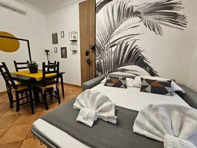 a hotel room with a bed and a table with a table at Be Your Home - Giulio's Apartment in Rome