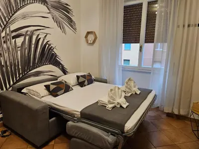 a bedroom with a bed and a couch and a window at Be Your Home - Giulio's Apartment in Rome