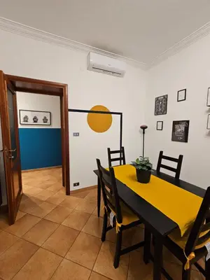 a dining room with a yellow table and chairs at Be Your Home - Giulio's Apartment in Rome