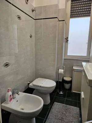 a bathroom with a white toilet and a sink at Be Your Home - Giulio's Apartment in Rome