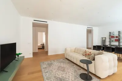 a living room with a white couch and a television at Popolo Design Apartment by RomeLoft in Rome