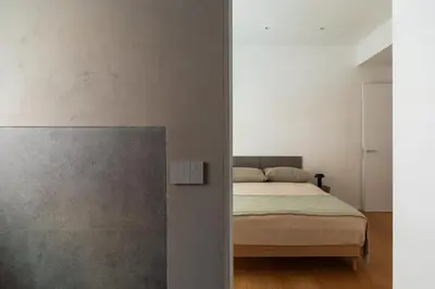a bedroom with a bed and a concrete wall at Popolo Design Apartment by RomeLoft in Rome