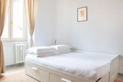 a white bed with white sheets and pillows on it at Dimora Romana - Vintage Elegance and Modern Comfort in Rome