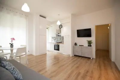 a white living room with a table and a television at Civico Appia Apartment in Rome