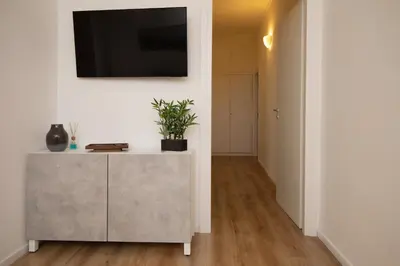 a living room with a cabinet with a tv on a wall at Civico Appia Apartment in Rome
