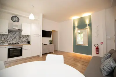 a kitchen and living room with white cabinets at Civico Appia Apartment in Rome