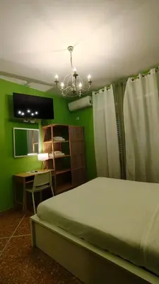 a bedroom with a bed and a desk and a chandelier at Appartamenti Romolo E Remo in Rome