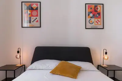 a bedroom with a bed with two lamps and two pictures at Qflat Elegant Palumbo Vatican in Rome