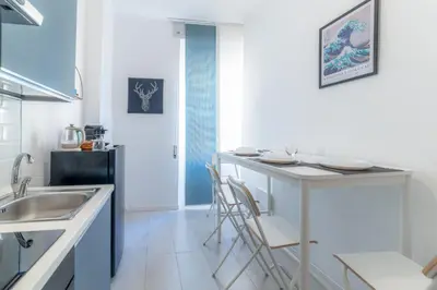 a kitchen with a sink and a counter with chairs at Qflat Elegant Palumbo Vatican in Rome