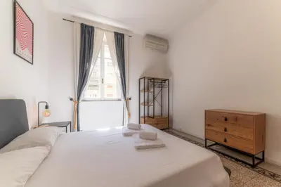 a bedroom with a white bed and a dresser and a window at Qflat Elegant Palumbo Vatican in Rome