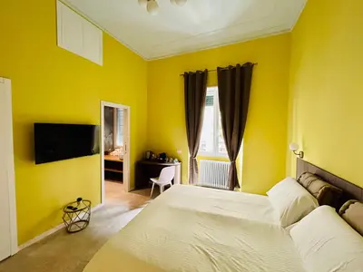a yellow bedroom with a bed and a television at Aura Roma in Rome