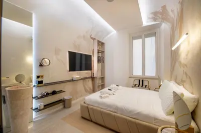 a bedroom with a bed and a tv on a wall at Borghese Boutique in Rome