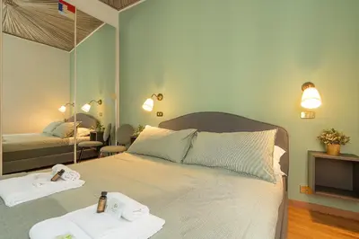 a bedroom with a bed with two towels and a mirror at Frattina Cozy Flat Spanish Steps in Rome