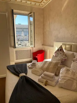 a bedroom with a large bed with pillows and a window at Piazza Venezia appartamento con vista in Rome