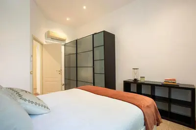 a bedroom with a white bed and a black cabinet at Casa Mia in Rome