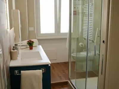 a bathroom with a sink and a glass shower at La Casa dei Lettori in Rome